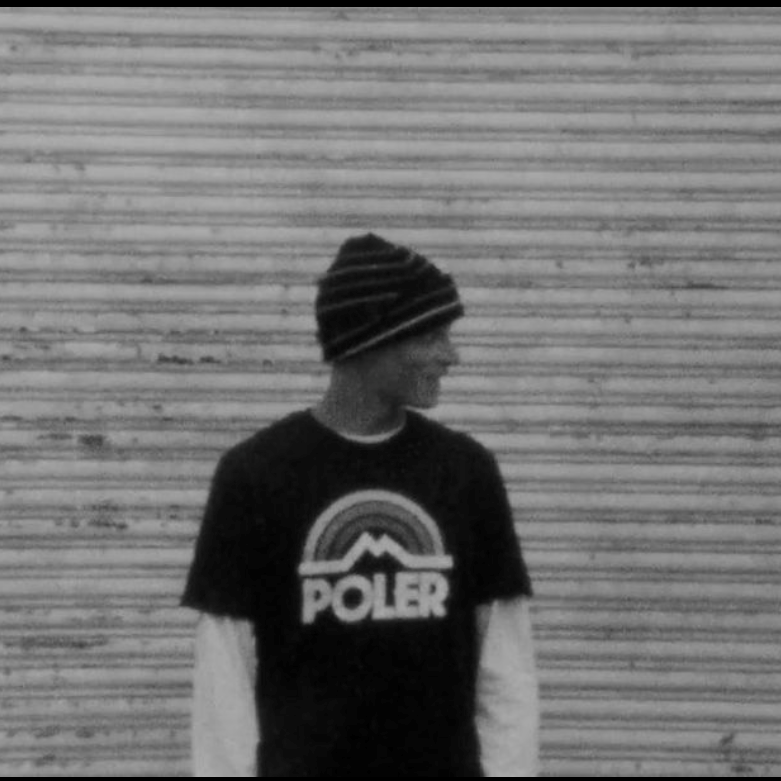 Black-and-white portrait of Zach Miller in a striped beanie and Poler rainbow logo tee